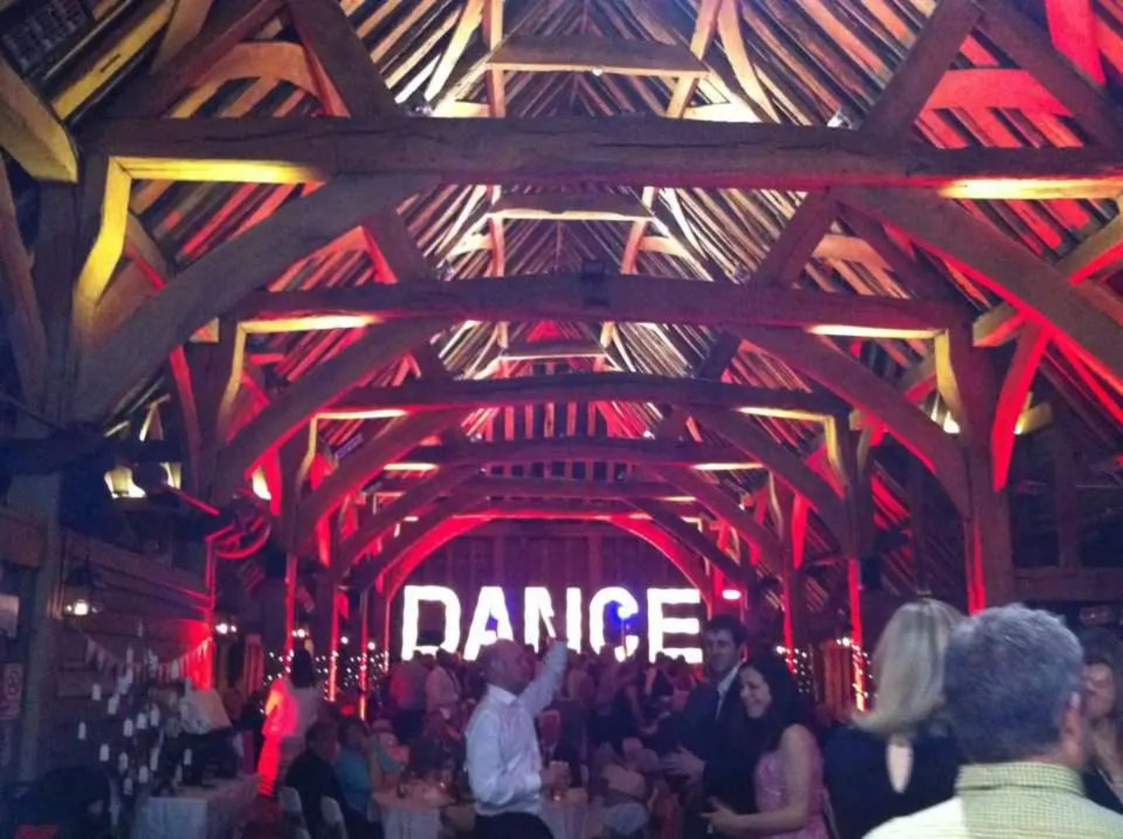 Guests dancing energetically at a barn wedding reception