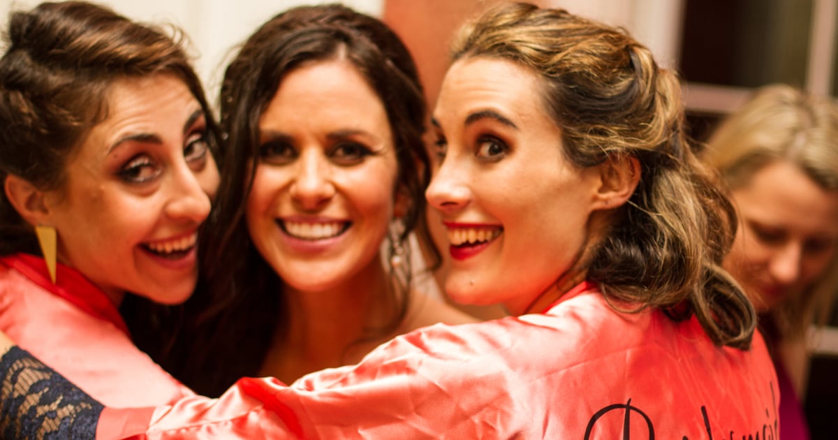 Bridesmaids hugging and smiling at a wedding reception