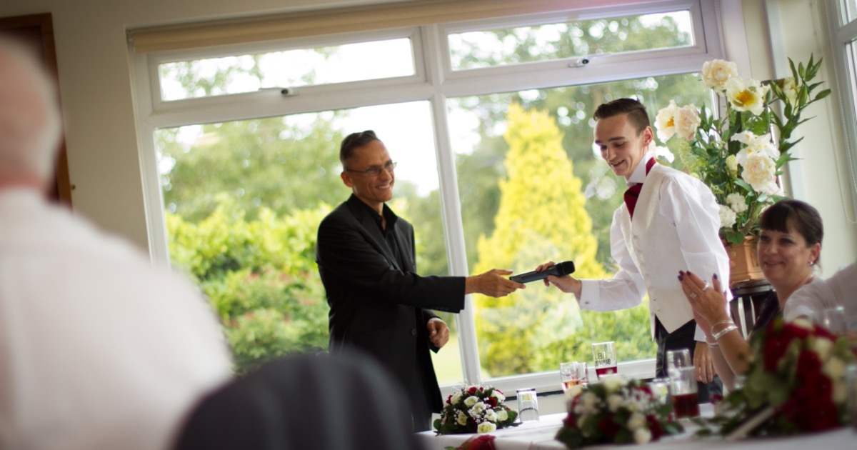 Wedding MC coordinating behind the scenes while guests enjoy the celebration
