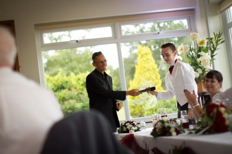 Wedding MC coordinating behind the scenes while guests enjoy the celebration